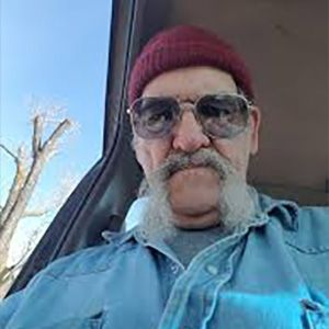 headshot of man with handlebar mustache wearing glasses and beanie